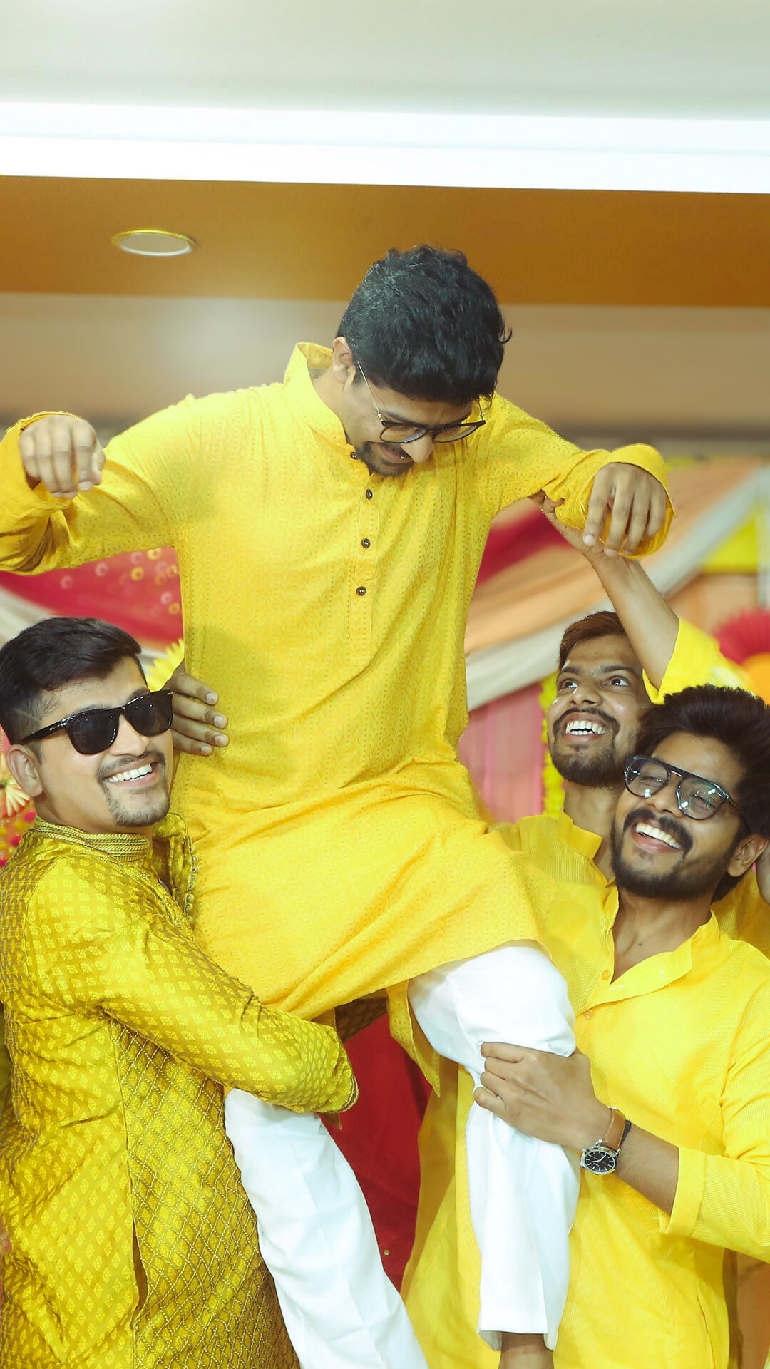 Grooms men holding groom on their shoulder and enjoying in wedding ceremony